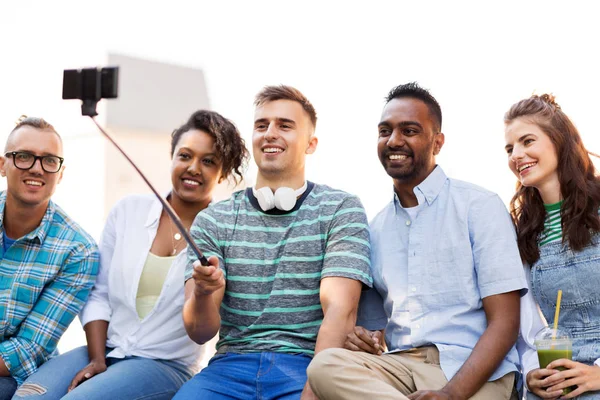 Amigos tomando fotos en selfie stick en la ciudad — Foto de Stock