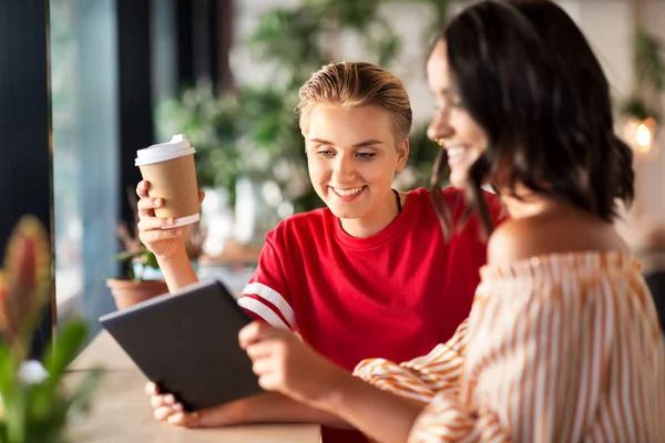 Amigos do sexo feminino com tablet pc e café no café — Fotografia de Stock