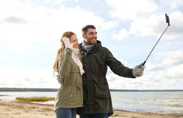 Lyckliga paret tar selfie på stranden i höst — Stockfoto