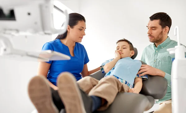 Отец и сын посещают дантиста в стоматологической клинике — стоковое фото
