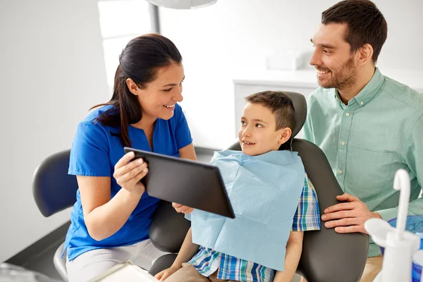 歯科医院で子供にタブレット pc を示す歯科医 — ストック写真