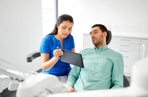 Dentista e paciente com tablet pc na clínica — Fotografia de Stock