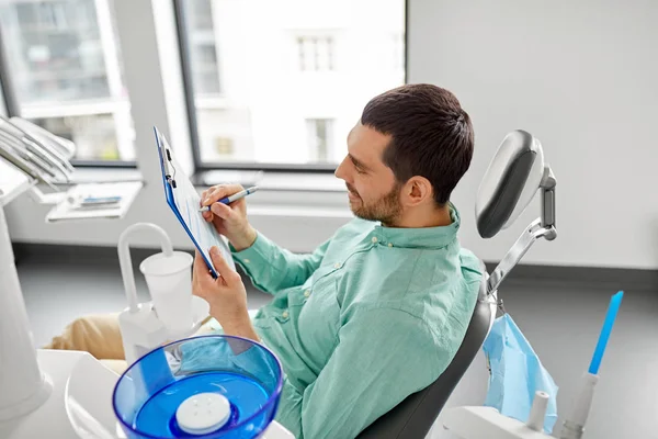 Ασθενής συμπληρώνοντας την φόρμα συμμετοχής στο οδοντιατρείο — Φωτογραφία Αρχείου