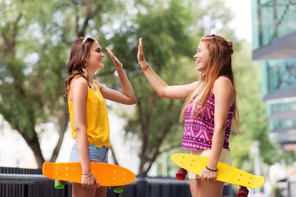 Девушки-подростки со скейтбордами дают пять — стоковое фото