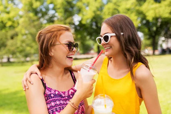 Teenage girls with milk shakes at summer park — Stock Photo, Image