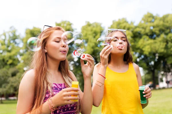 Teenage girls blowing bubbles at summer park — Stock Photo, Image