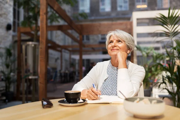 Senior vrouw met laptop dromen op straat Cafe — Stockfoto