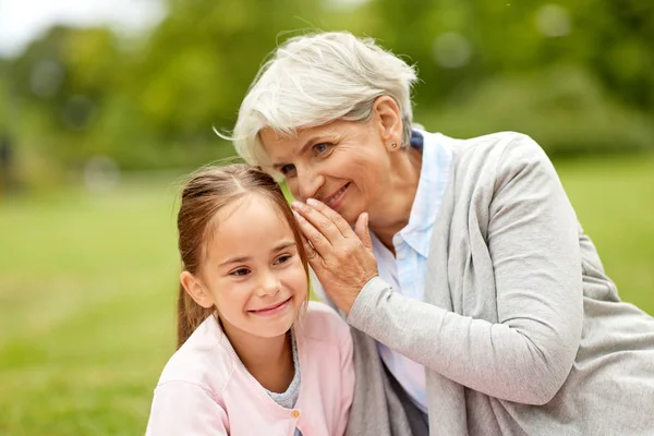 Kleindochter delen van geheimen met oma — Stockfoto