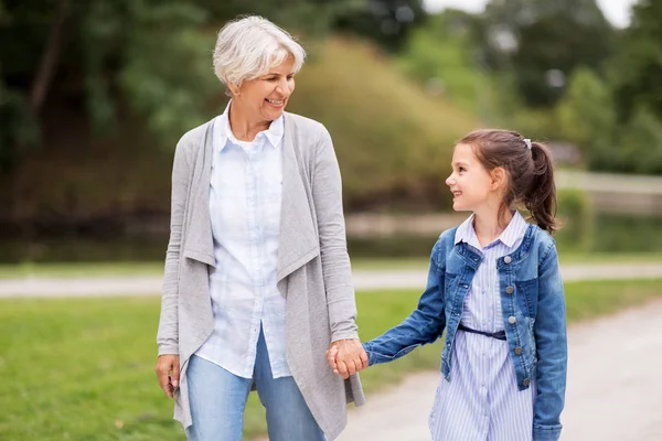 Mormor och barnbarn promenader på park — Stockfoto