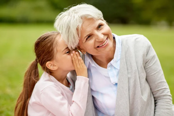 Kleindochter delen van geheimen met oma — Stockfoto