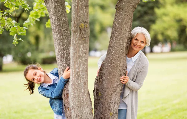 Büyükanne ve torunu Park ağacın arkasında — Stok fotoğraf