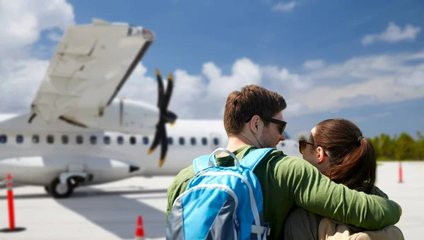 Couple of tourists with backpacks over airplane — Stock Photo, Image