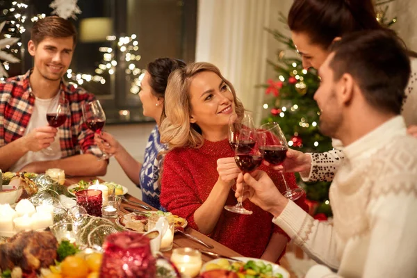 Amigos celebrando la Navidad y bebiendo vino —  Fotos de Stock