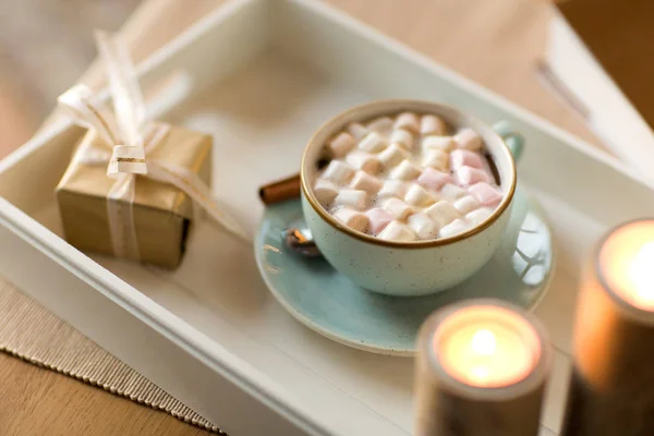 Chocolate quente, presente de Natal e velas na mesa — Fotografia de Stock