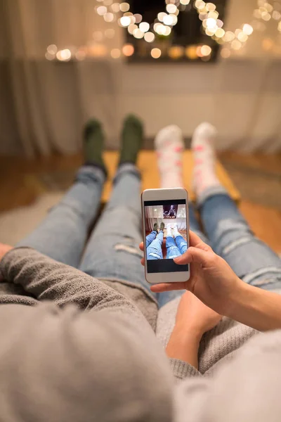 Zblízka pár vzal nohy Foto smartphone — Stock fotografie