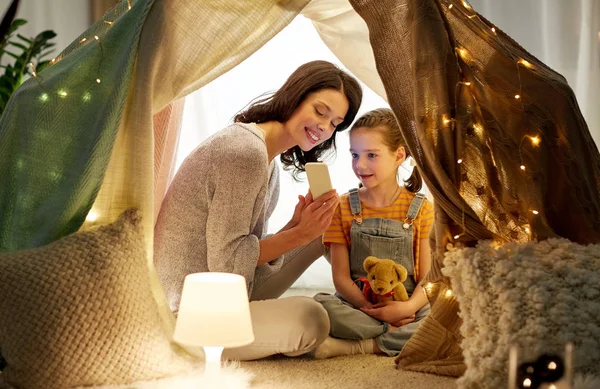 Glückliche Familie mit Smartphone im Kinderzelt zu Hause — Stockfoto