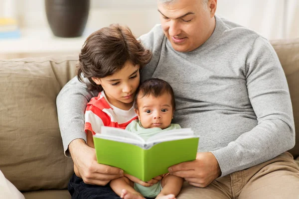 Szczęśliwy ojciec z synami, czytanie książki w domu — Zdjęcie stockowe