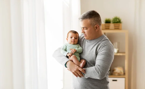 Feliz padre sosteniendo con pequeño bebé hijo en casa — Foto de Stock