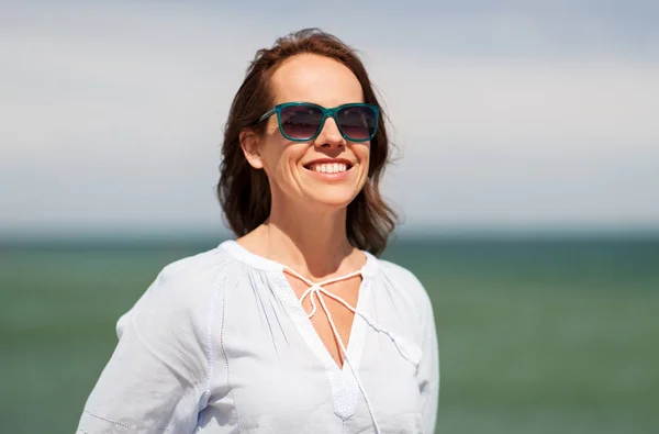 Gelukkig lachende vrouw in zonnebril op zomer-strand — Stockfoto
