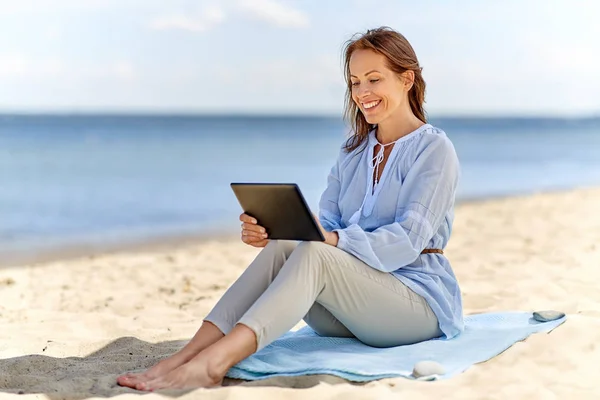 Mulher sorridente feliz com tablet pc na praia de verão — Fotografia de Stock