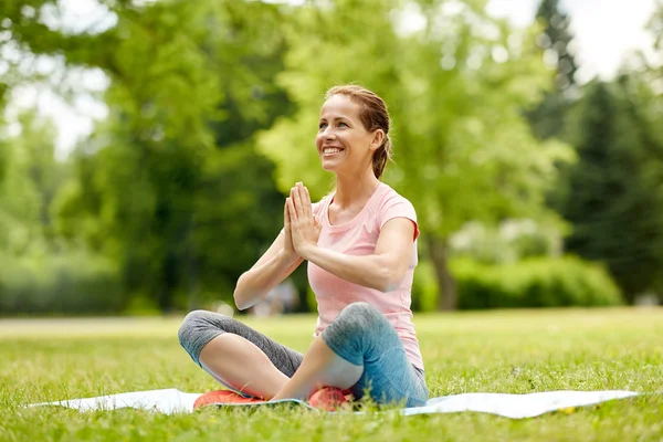 Gelukkige vrouw mediteren in zomer park — Stockfoto