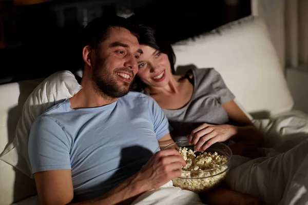 Casal com pipocas assistindo tv à noite em casa Fotos De Bancos De Imagens Sem Royalties
