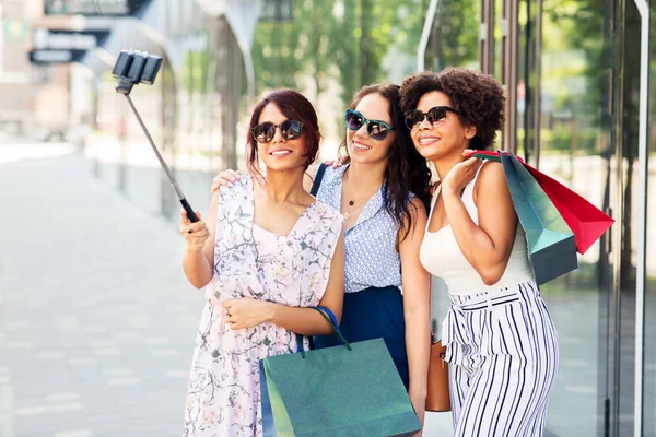 Vrouwen met boodschappentassen nemen selfie buiten — Stockfoto