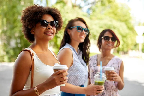 Glada kvinnor eller vänner med drinkar på sommaren park — Stockfoto