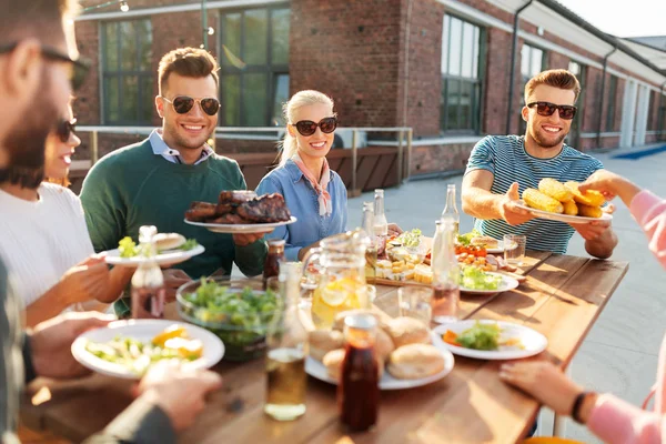 Ευτυχείς φίλοι τρώγοντας στο μπάρμπεκιου πάρτι στην ταράτσα — Φωτογραφία Αρχείου