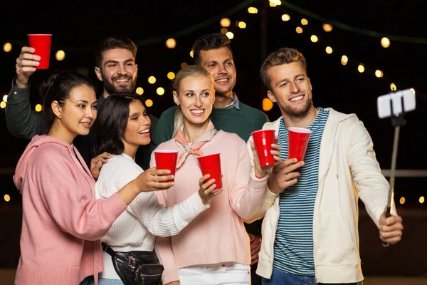 Amis avec des boissons prendre selfie à la fête sur le toit — Photo