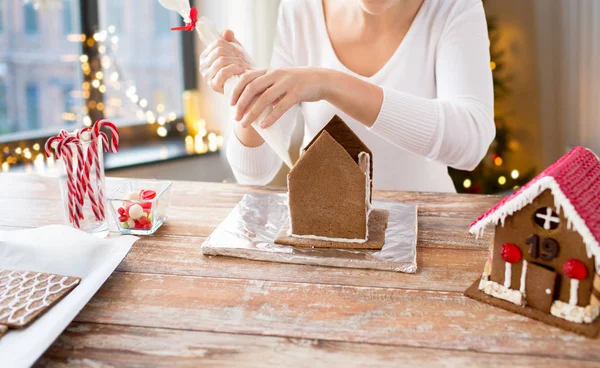 Mujer haciendo casas de jengibre en Navidad —  Fotos de Stock