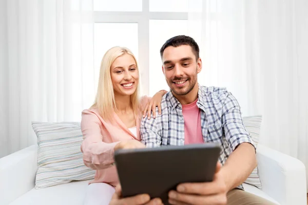 Casal feliz com computador tablet em casa — Fotografia de Stock