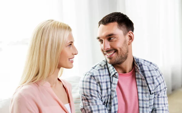 Sorrindo casal feliz abraçando no sofá em casa — Fotografia de Stock