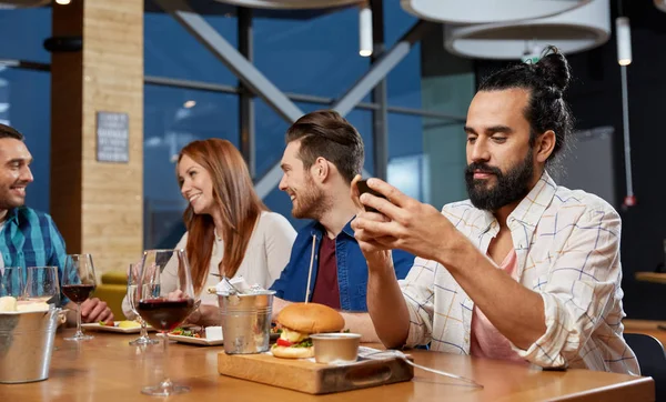 Człowiek, wiadomości na smartfonie w restauracji — Zdjęcie stockowe