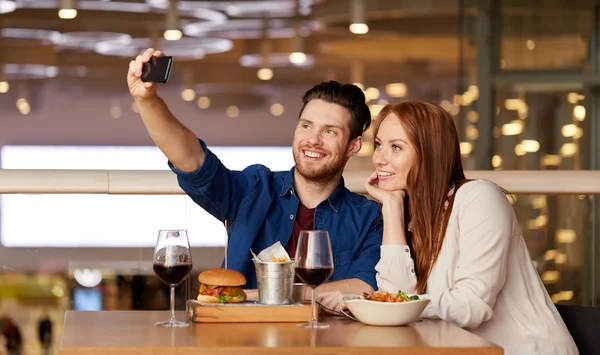 Pár selfie brát do smartphone v restauraci — Stock fotografie