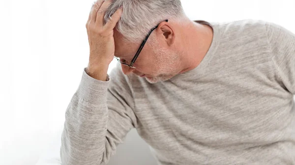 Homem idoso que sofre de dor de cabeça em casa — Fotografia de Stock
