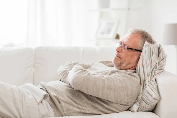 Tankeväckande senior man liggande på soffan hemma — Stockfoto