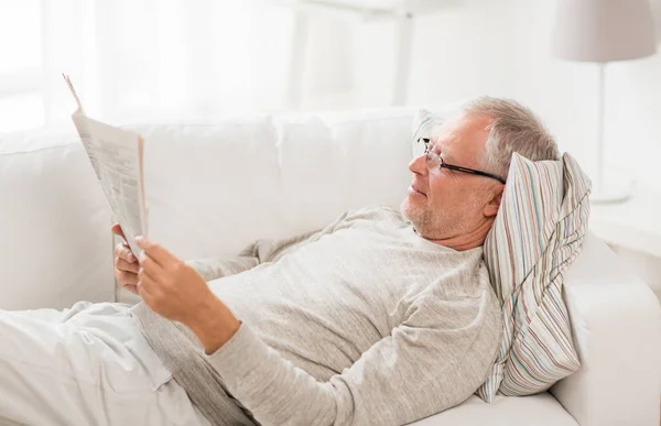 Hombre mayor leyendo el periódico en casa — Foto de Stock