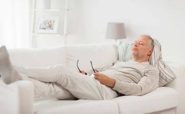 Senior man sleeping on sofa at home — Stock Photo, Image