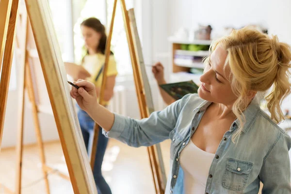 Kvinna med staffli ritning på konst skolan studio — Stockfoto