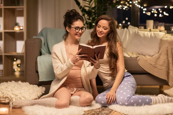 Heureux amis féminins lecture livre à la maison — Photo