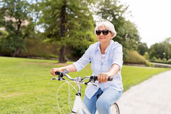 Glückliche Seniorin mit Fahrrad im Sommerpark — Stockfoto