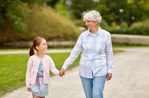 Бабушка и внучка гуляют в парке — стоковое фото