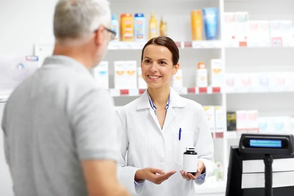 Speziale e cliente anziano in farmacia — Foto Stock