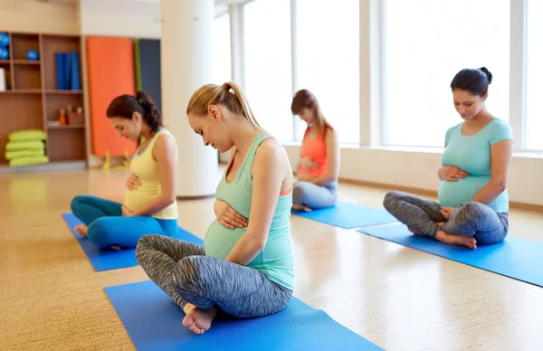 Felici donne incinte che esercitano in palestra yoga — Foto Stock