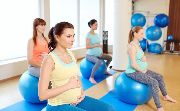 Беременные женщины сидят на тренировочных мячах в спортзале — стоковое фото