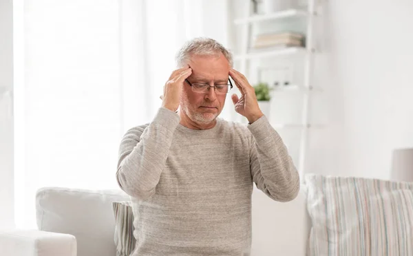 Senior man suffering from headache at home — Stock Photo, Image