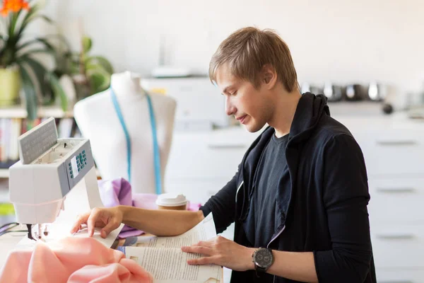 Fashion designer reading book at studio — Stock Photo, Image