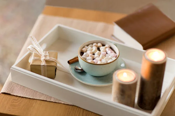 Hot chocolate, christmas gift and candles on table — Stock Photo, Image