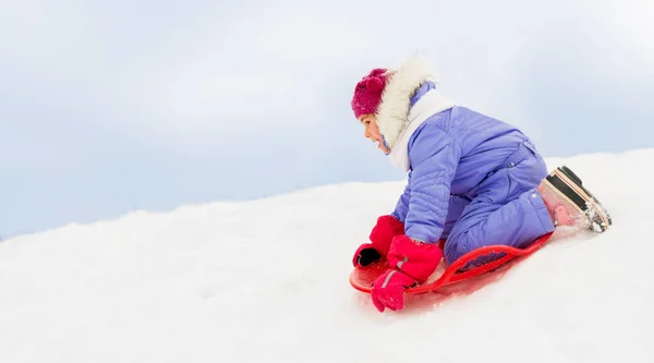 冬の受け皿の雪のそりの上を滑りの女の子 — ストック写真